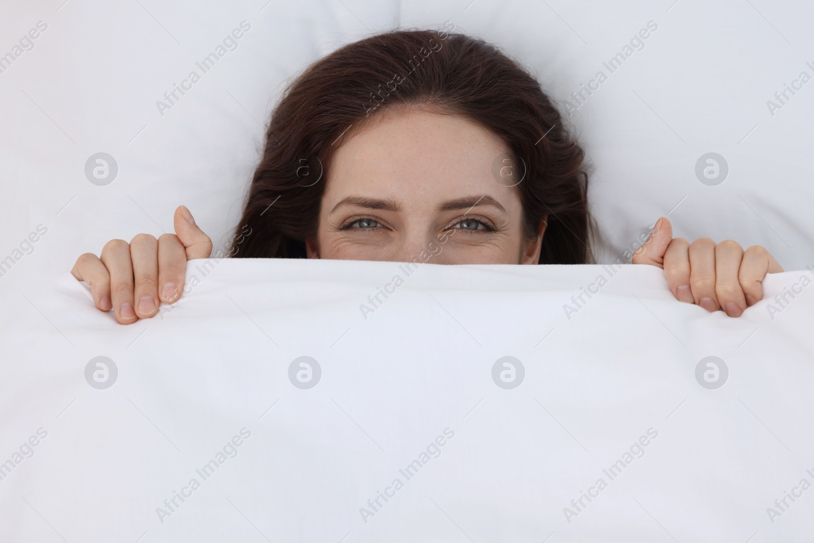 Photo of Bedtime. Woman lying in bed indoors, top view