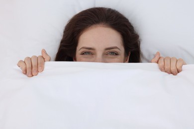 Bedtime. Woman lying in bed indoors, top view