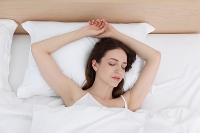 Photo of Bedtime. Woman sleeping in bed at home, top view