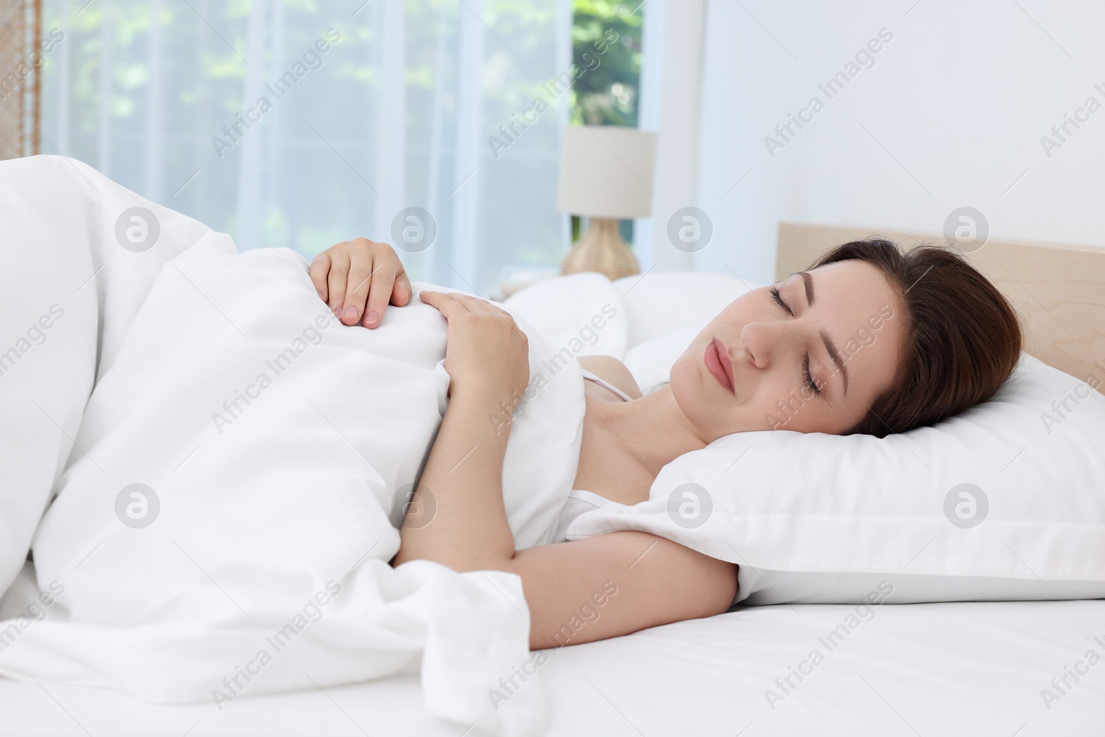 Photo of Bedtime. Woman sleeping in bed at home