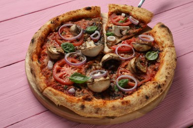Photo of Tasty pizza with mushrooms, basil and tomatoes on pink wooden table, closeup