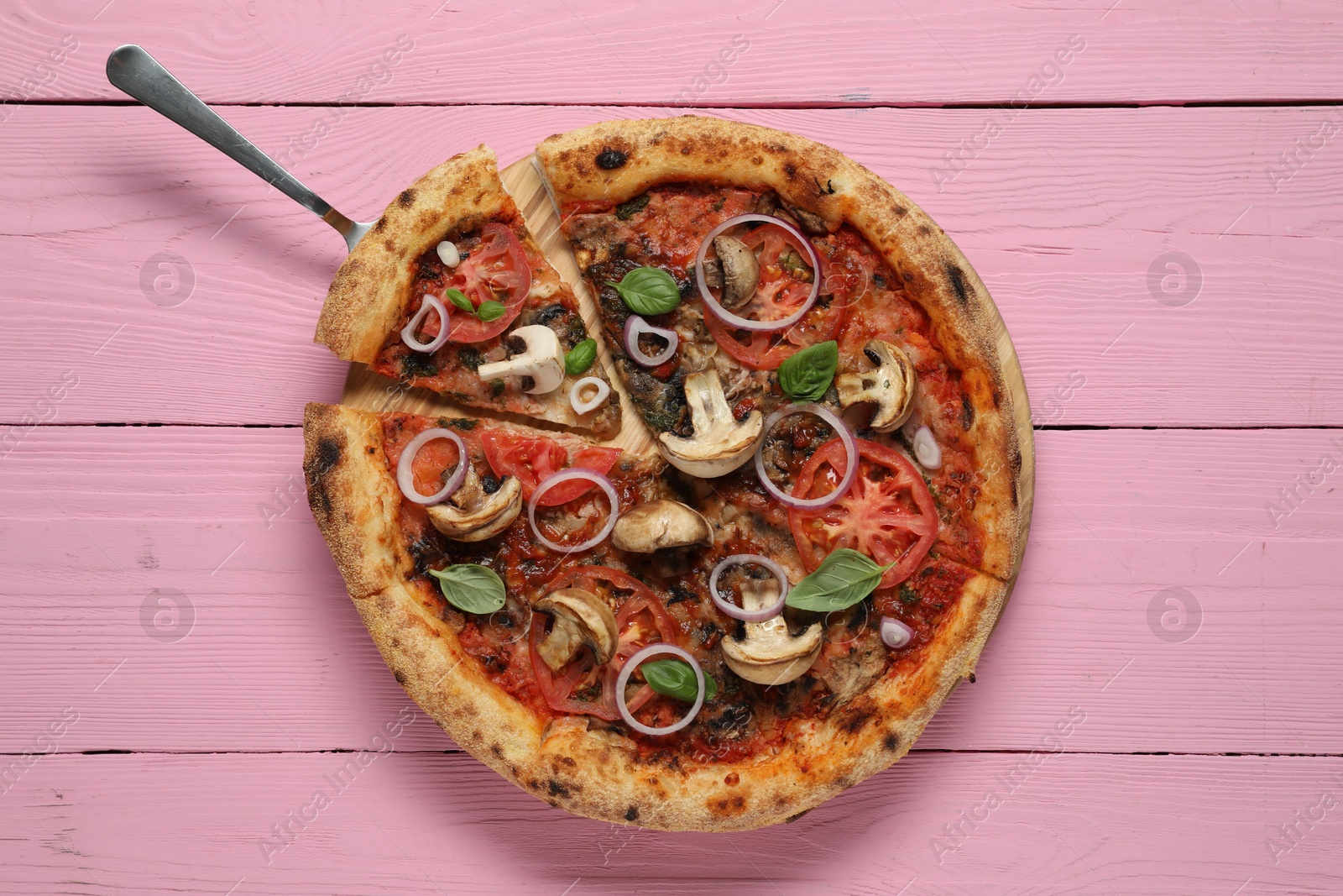 Photo of Tasty pizza with mushrooms, basil and tomatoes on pink wooden table, top view