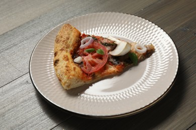 Photo of Piece of tasty pizza with mushrooms, basil and tomato on wooden table