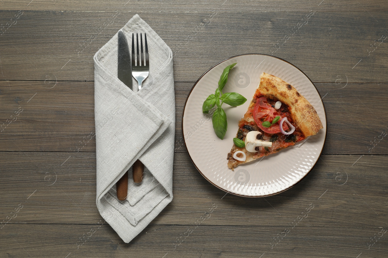 Photo of Piece of tasty pizza with mushrooms, basil and tomato served on wooden table, flat lay