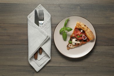 Photo of Piece of tasty pizza with mushrooms, basil and tomato served on wooden table, flat lay