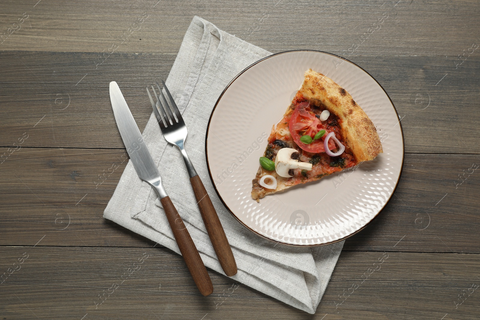 Photo of Piece of tasty pizza with mushrooms, basil and tomato served on wooden table, flat lay