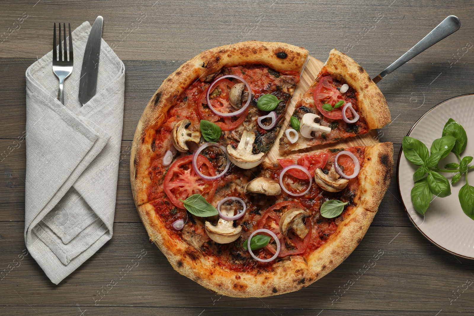 Photo of Tasty pizza with mushrooms, basil and tomatoes served on wooden table, flat lay