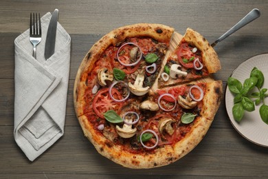 Photo of Tasty pizza with mushrooms, basil and tomatoes served on wooden table, flat lay
