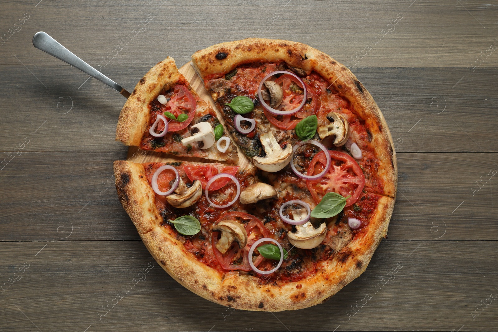 Photo of Tasty pizza with mushrooms, basil and tomatoes on wooden table, top view