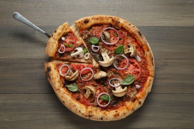 Photo of Tasty pizza with mushrooms, basil and tomatoes on wooden table, top view