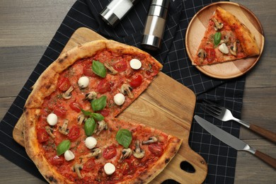 Photo of Tasty pizza with mushrooms, mozzarella and tomatoes served on wooden table, flat lay