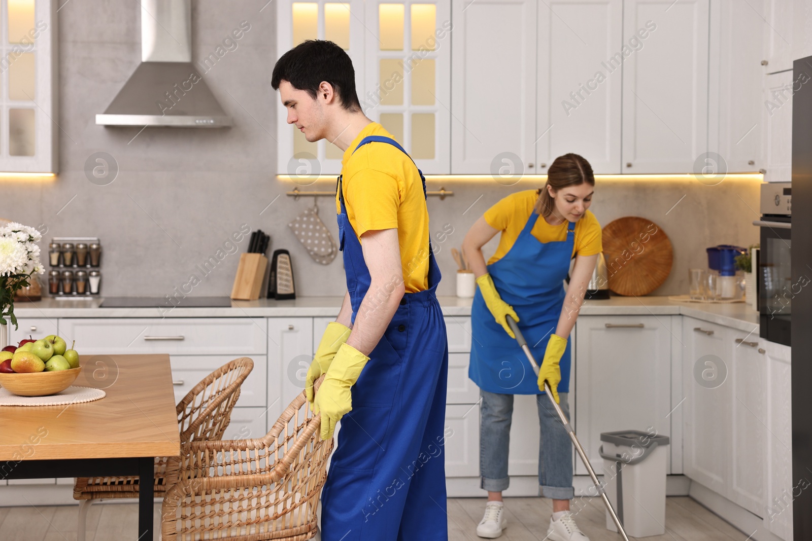 Photo of Professional janitors working in kitchen. Cleaning service