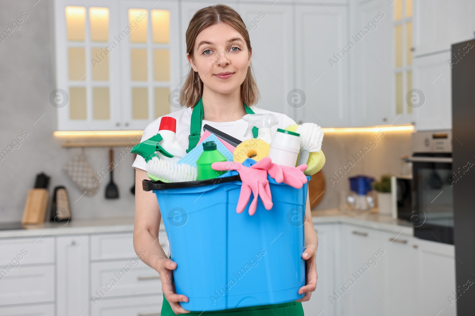 Photo of Cleaning service worker holding bucket with supplies in kitchen