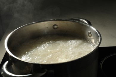 Photo of Boiling rice in metal pot on stove, closeup