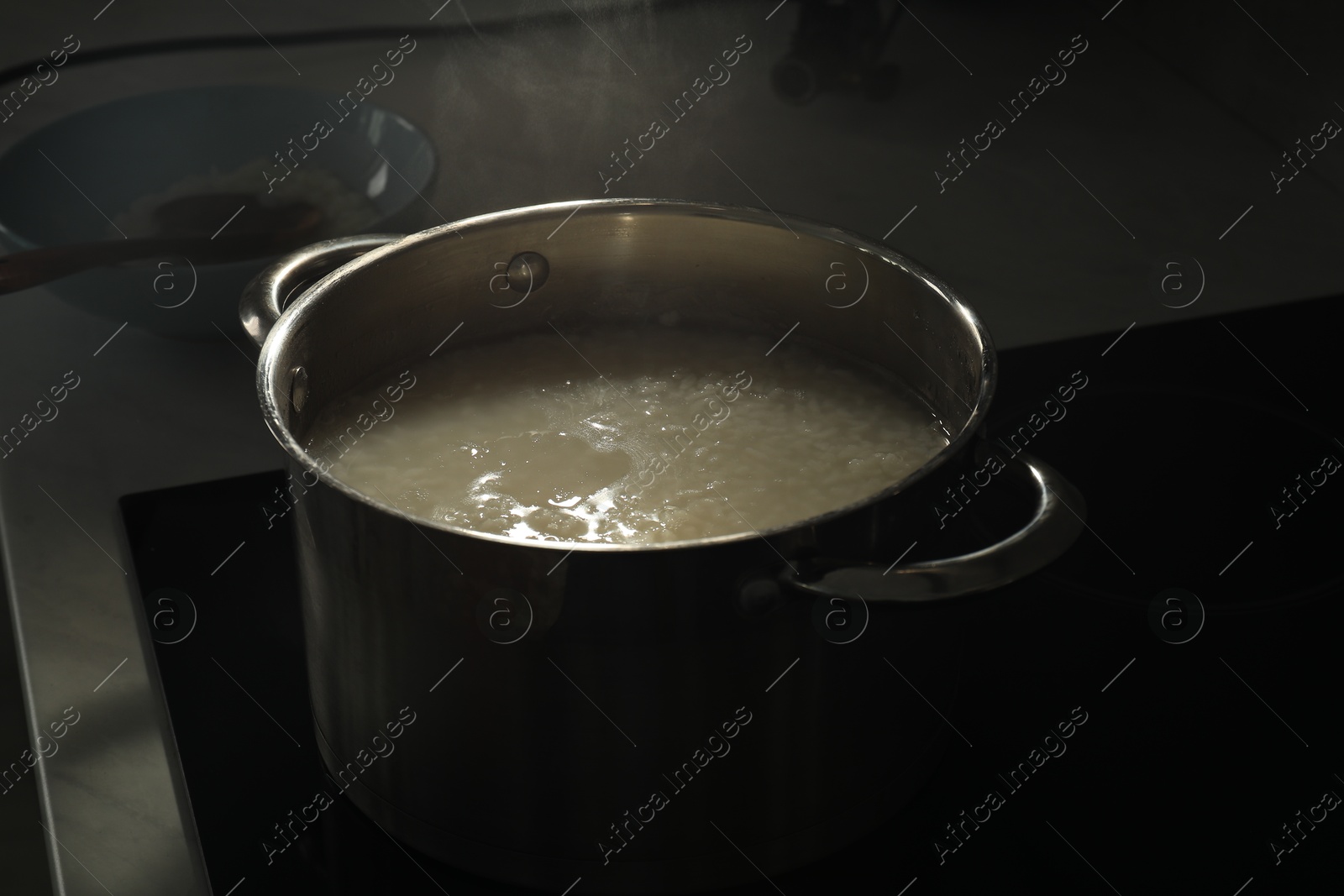 Photo of Boiling rice in metal pot on stove, closeup