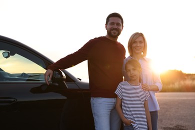 Photo of Cute family near car outdoors at sunset