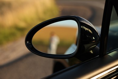Photo of Side view mirror of modern car outdoors, closeup