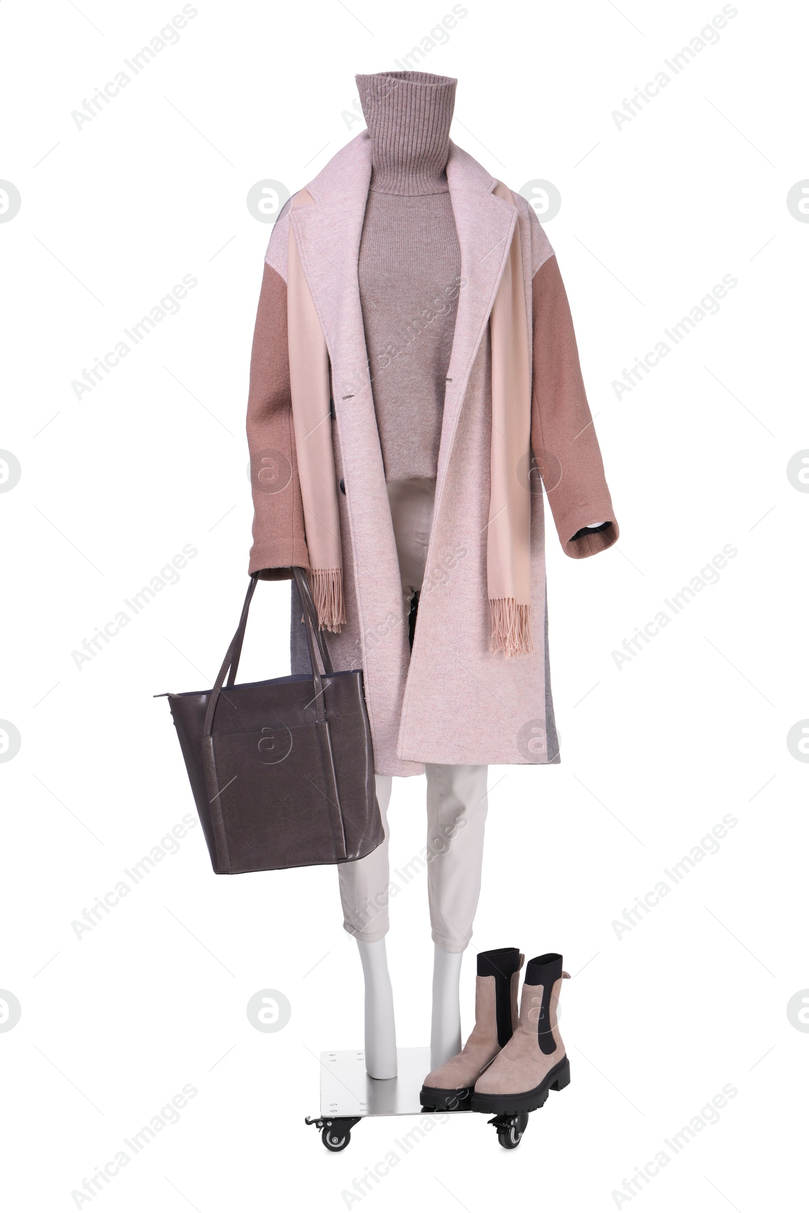 Photo of Female mannequin with accessories dressed in stylish coat, sweater and pants isolated on white