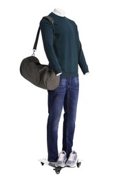 Photo of Male mannequin with bag dressed in stylish dark green sweatshirt and jeans isolated on white