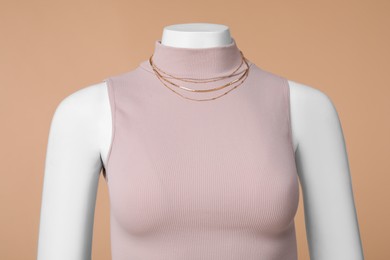 Photo of Female mannequin with necklace dressed in stylish crop top on beige background