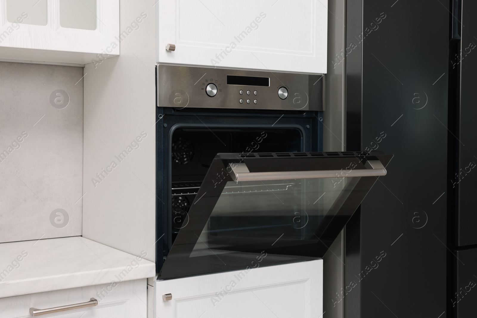 Photo of Open electric oven in kitchen. Cooking appliance