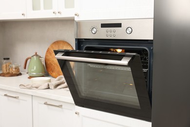 Photo of Open electric oven in kitchen. Cooking appliance