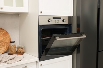 Photo of Open electric oven in kitchen. Cooking appliance