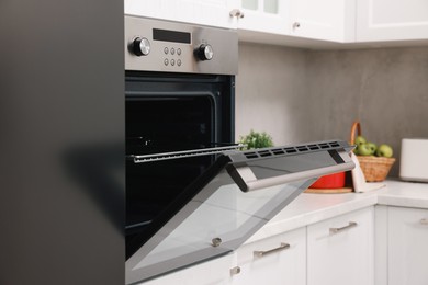 Photo of Open electric oven in kitchen. Cooking appliance