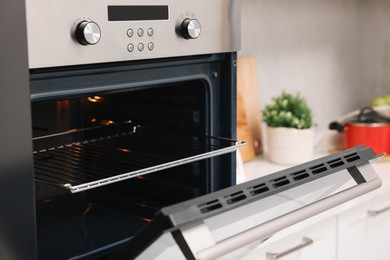 Photo of Open electric oven in kitchen. Cooking appliance