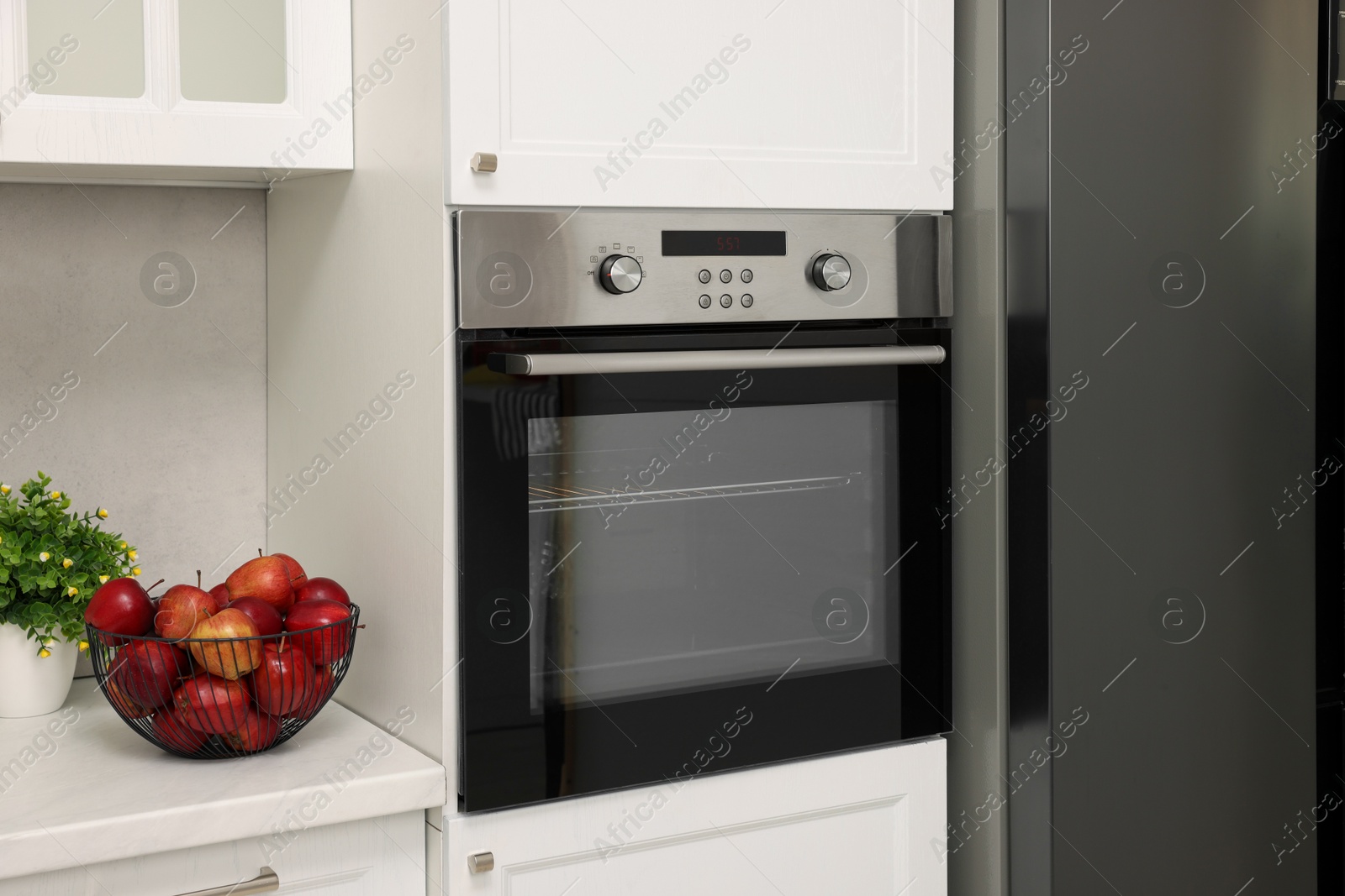 Photo of Electric oven and apples in kitchen. Cooking appliance