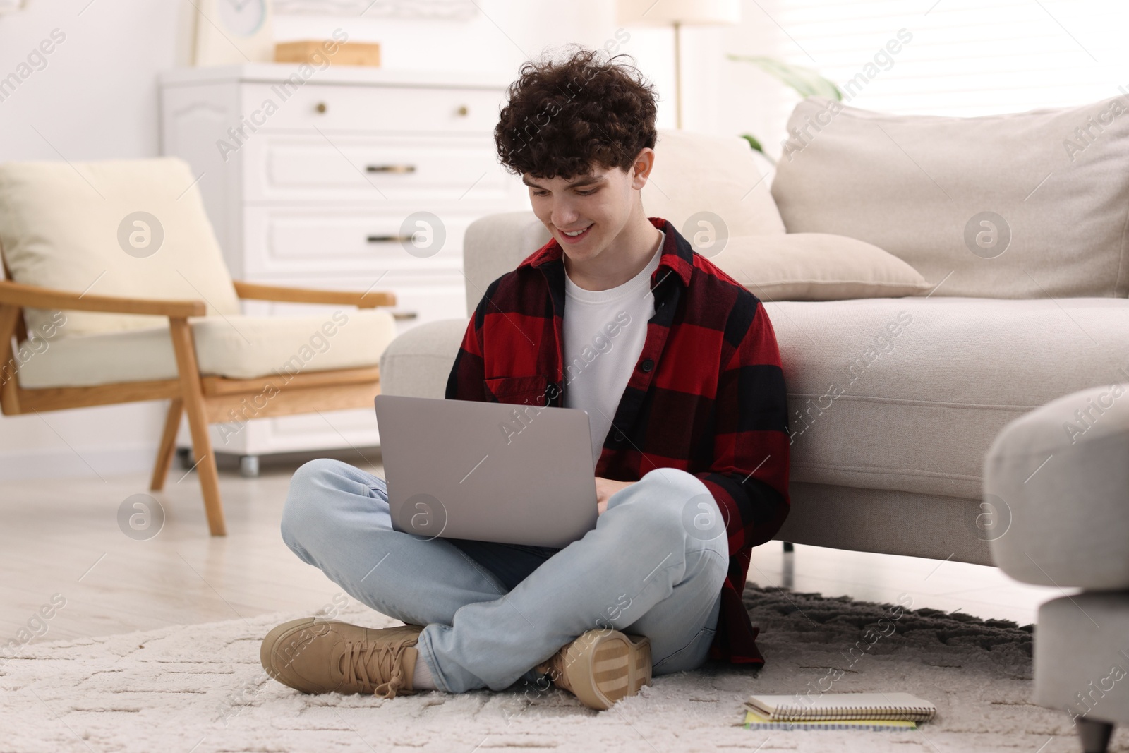 Photo of Teenager working with laptop at home. Remote job