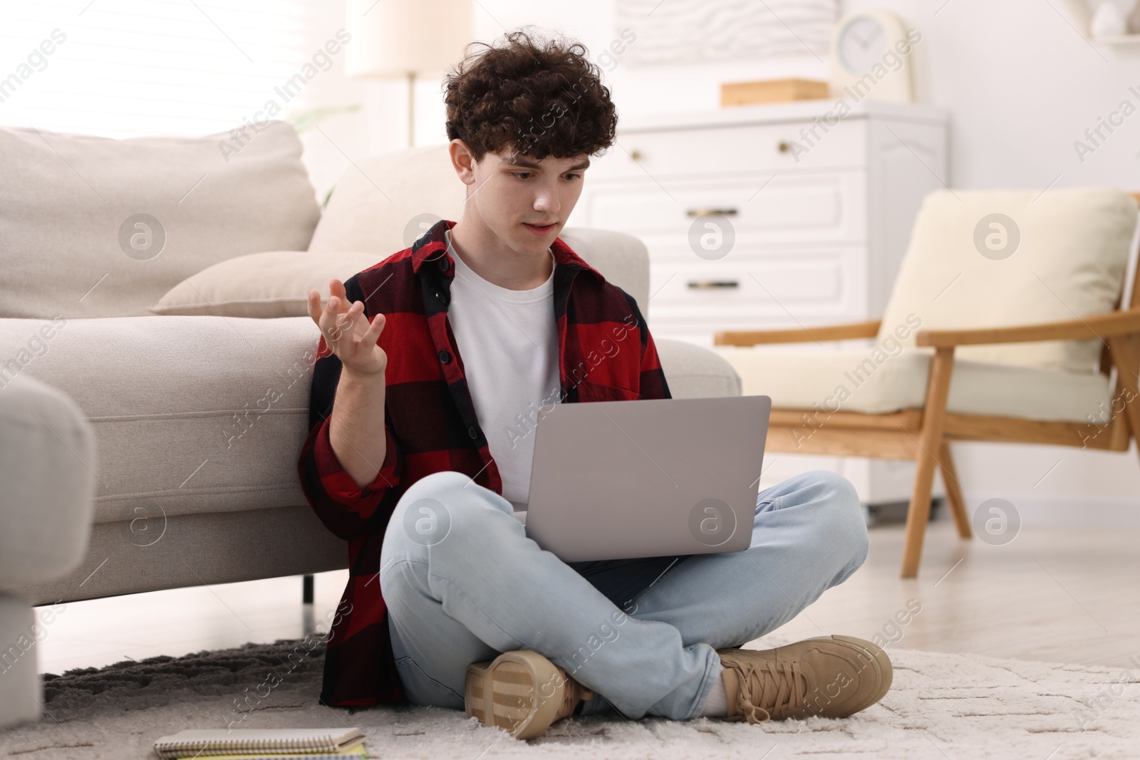 Photo of Teenager working with laptop at home. Remote job