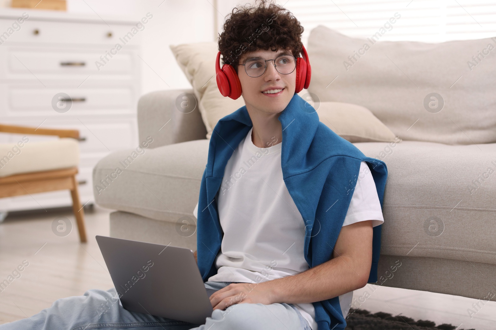 Photo of Teenager in headphones having video chat via laptop at home. Remote work