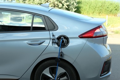 Photo of Charging modern electric car from station outdoors