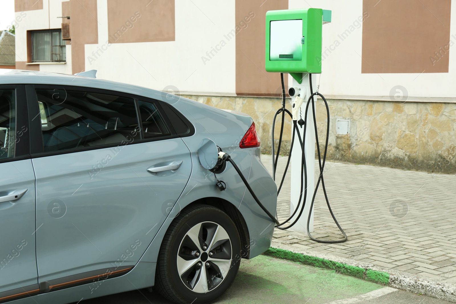 Photo of Modern electric car charging from station outdoors