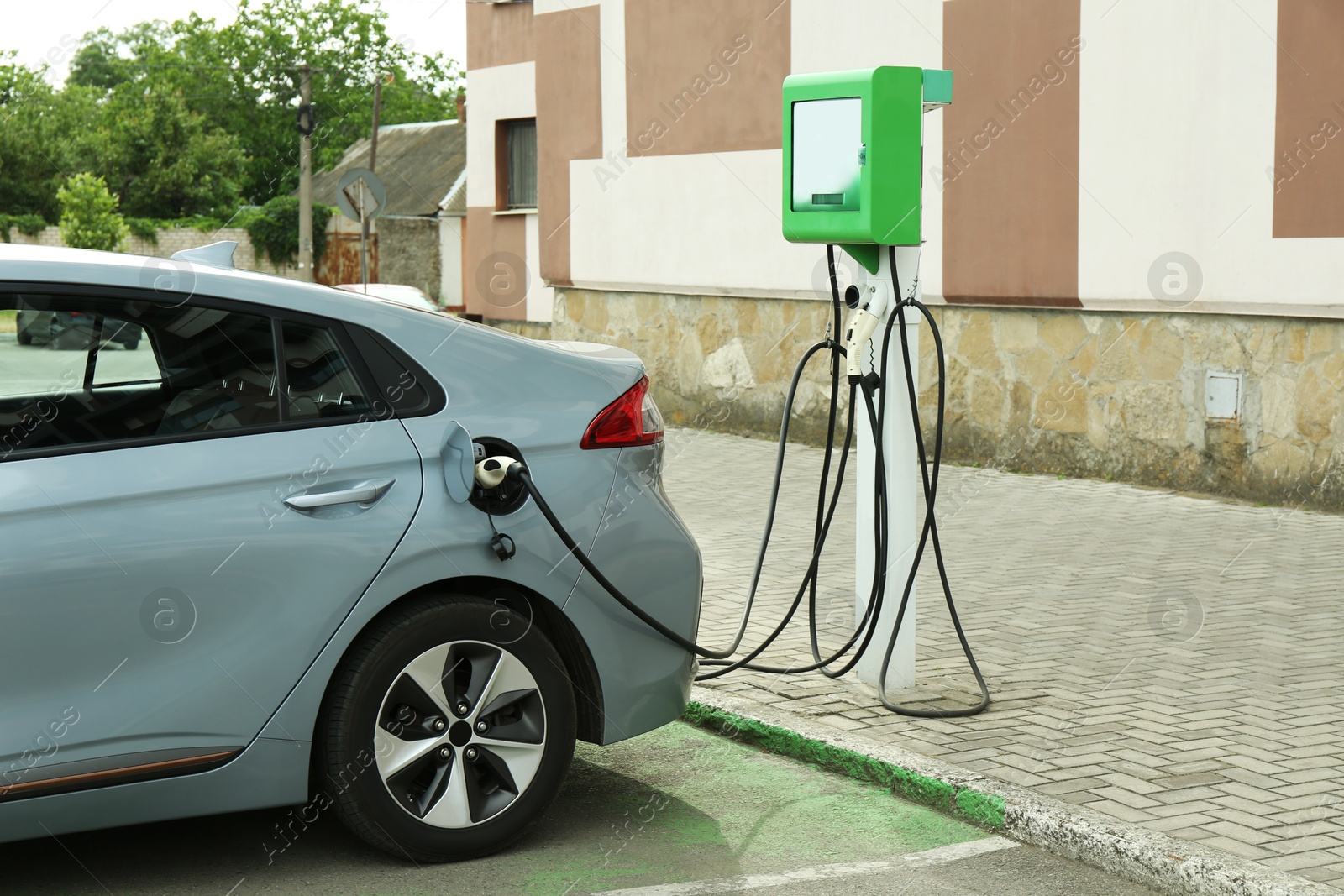 Photo of Modern electric car charging from station outdoors