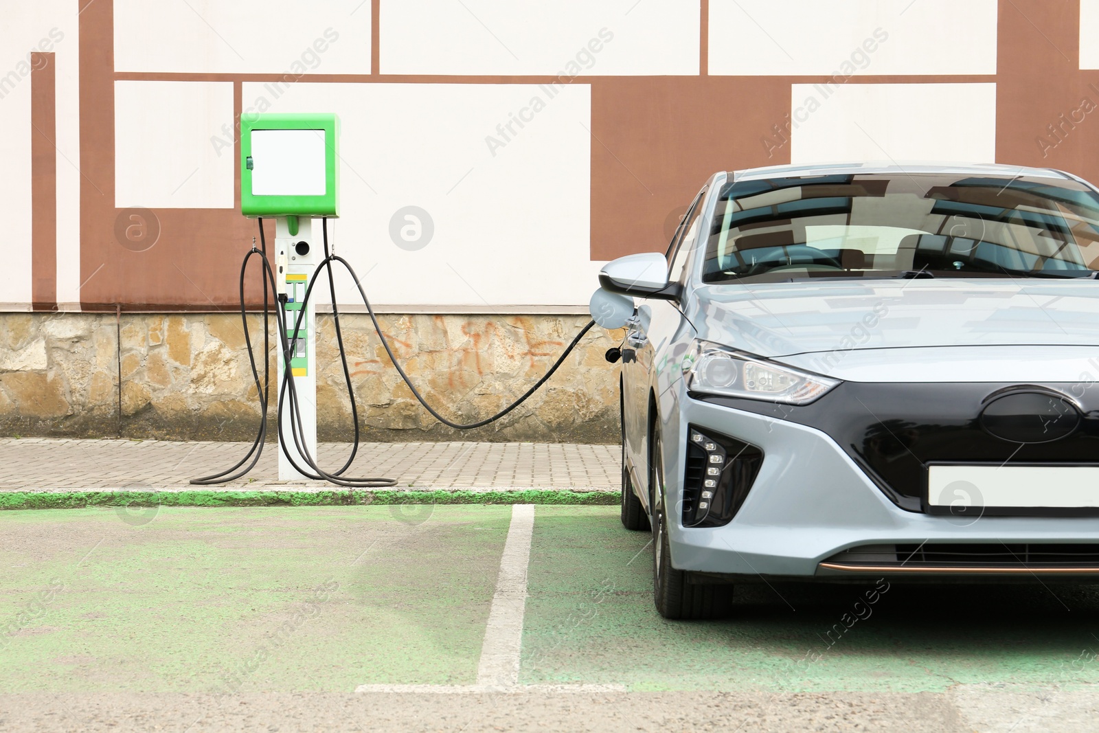 Photo of Modern electric car charging from station outdoors