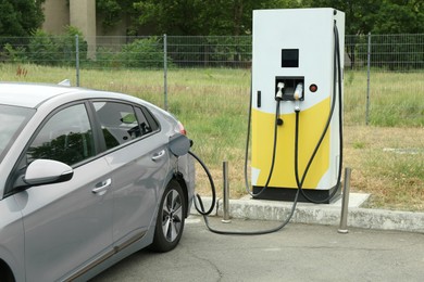 Photo of Modern electric car charging from station outdoors