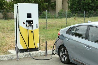 Photo of Modern electric car charging from station outdoors