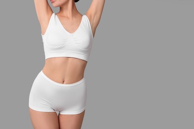 Photo of Slim woman with perfect skin in underwear on grey background, closeup with space for text. Body care