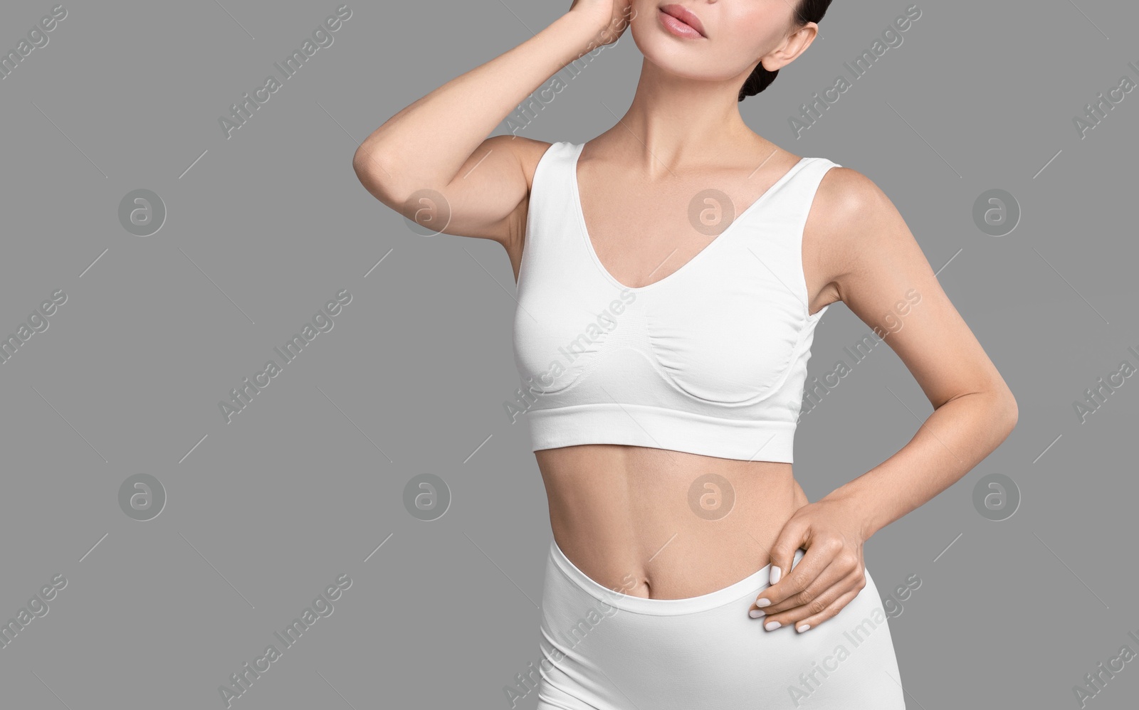 Photo of Woman with perfect skin in underwear on grey background, closeup with space for text. Body care