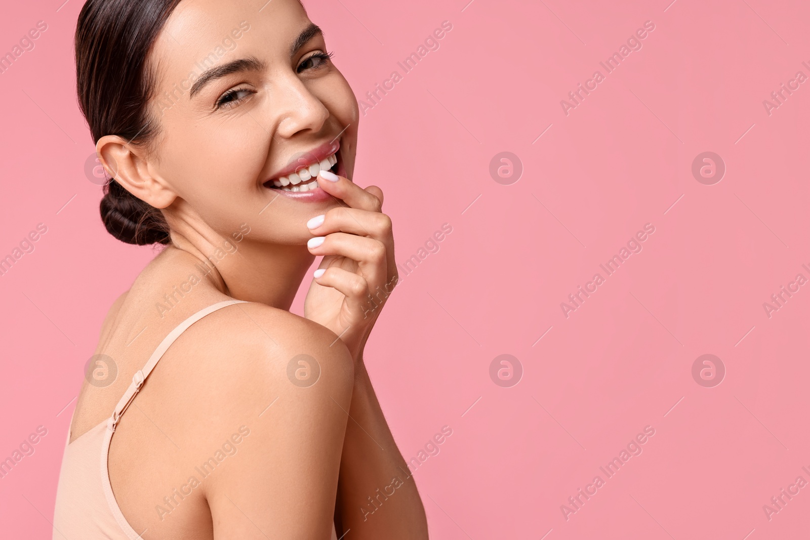 Photo of Smiling woman with perfect skin on pink background, space for text. Body care