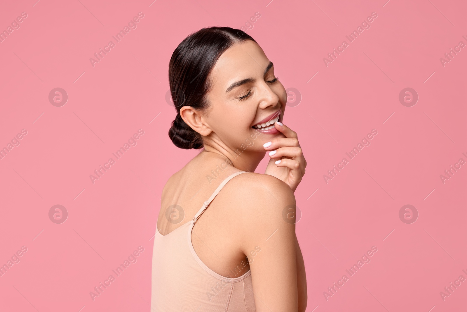 Photo of Smiling woman with perfect skin on pink background. Body care