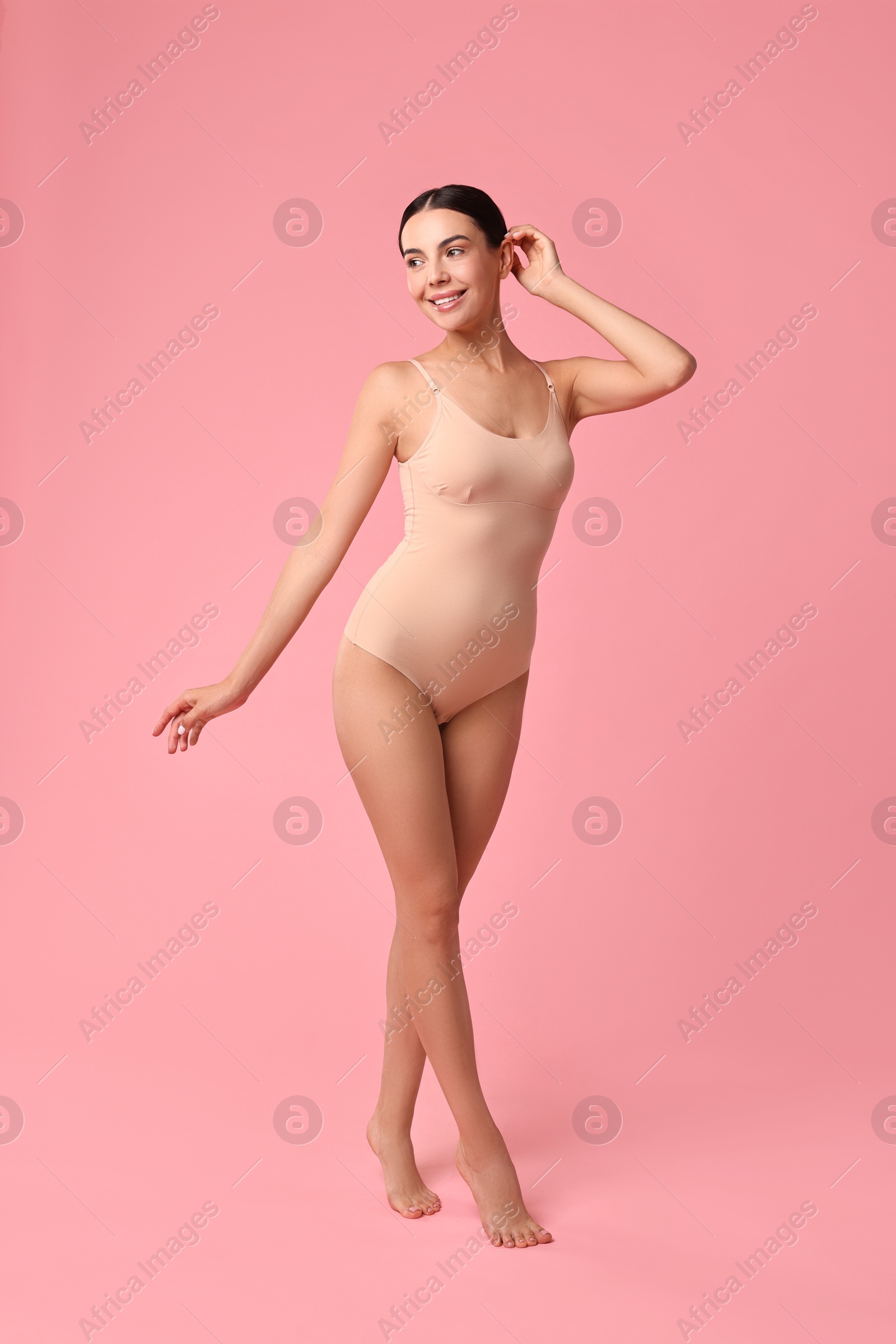 Photo of Smiling woman with perfect skin on pink background. Body care