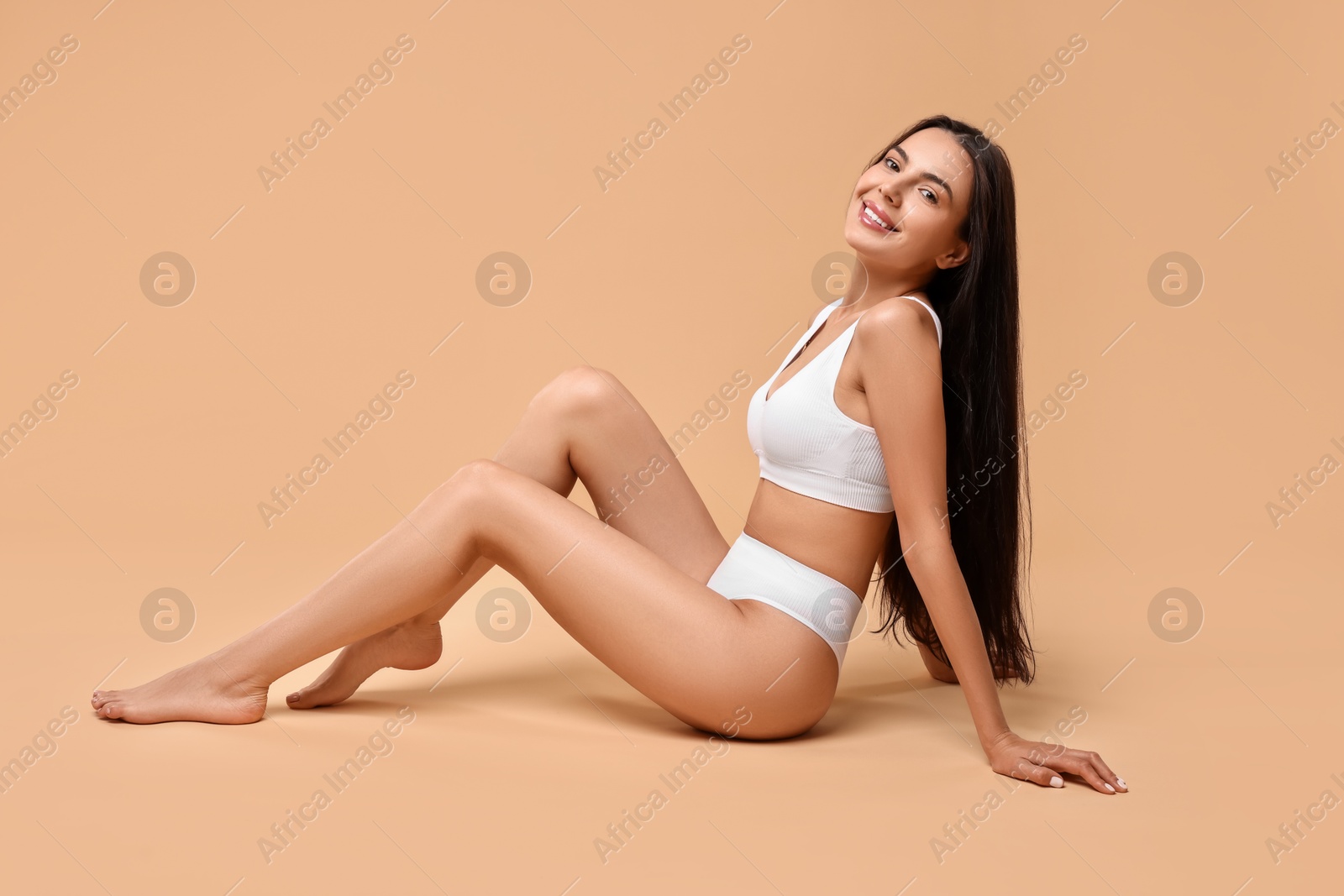 Photo of Smiling woman with perfect skin on beige background. Body care