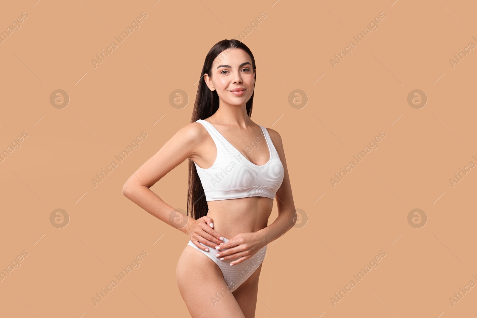 Photo of Beautiful woman with perfect skin in underwear posing on beige background. Body care