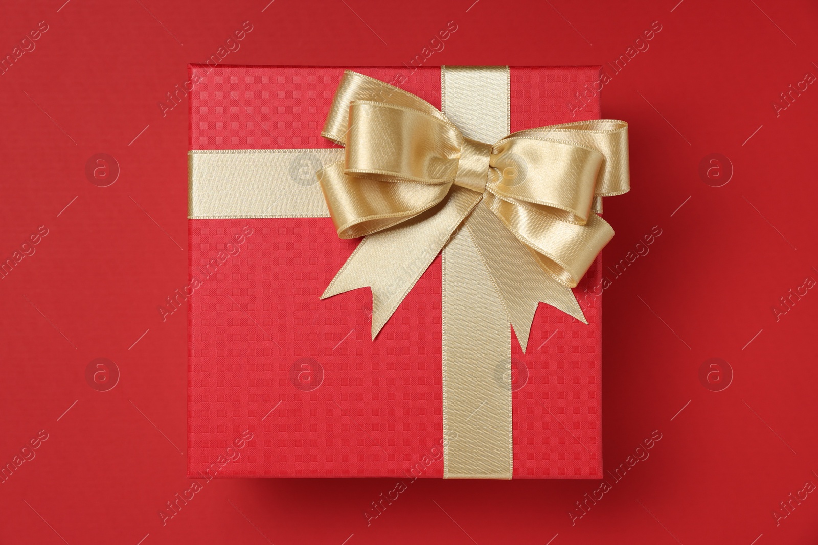 Photo of Gift box with bow on red background, top view