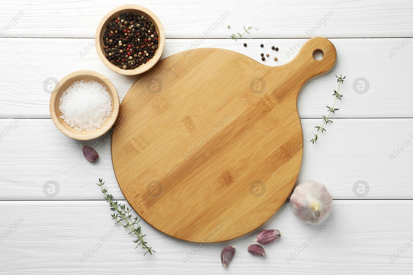 Photo of Cutting board and different spices on white wooden table, flat lay