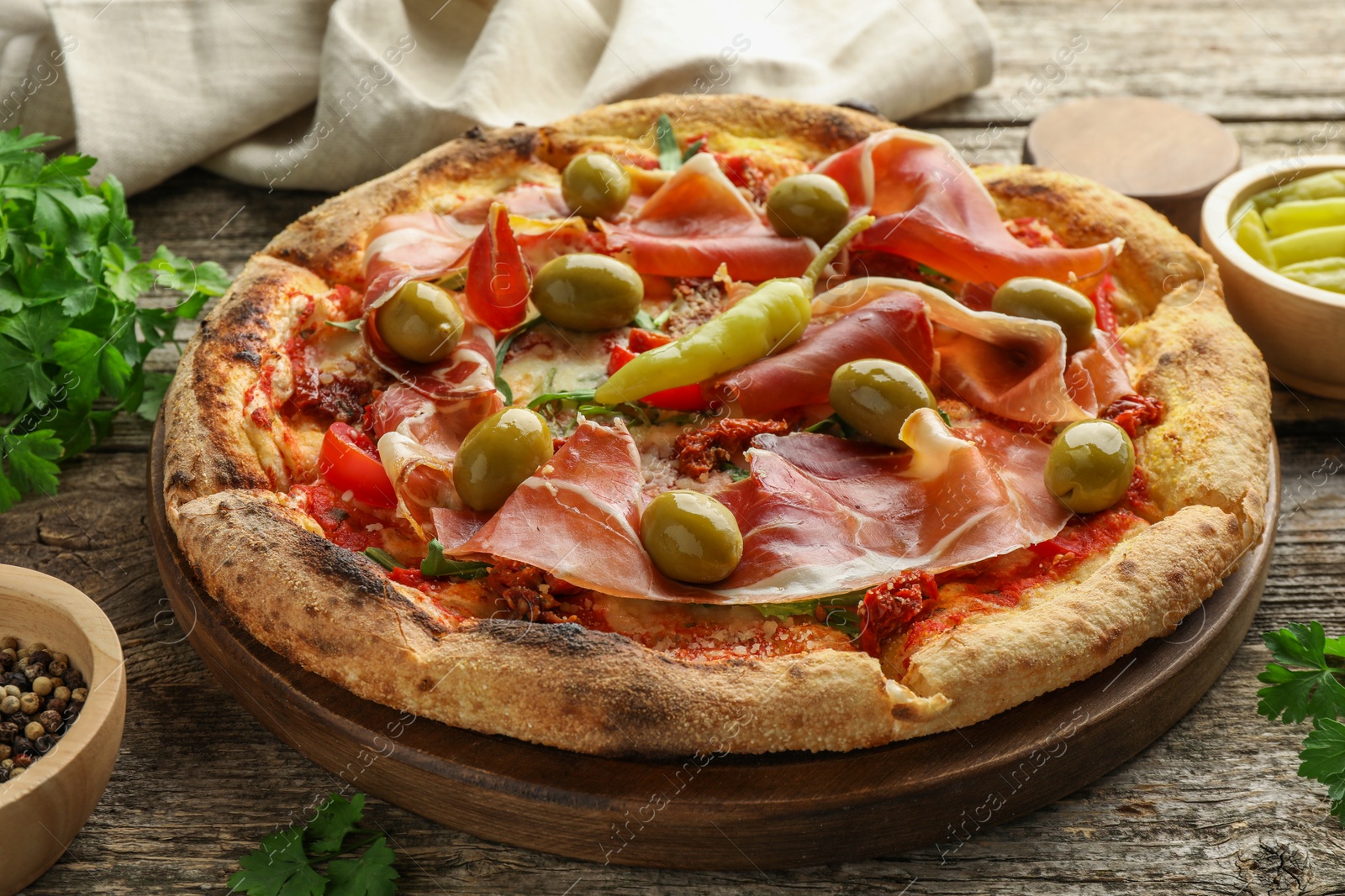 Photo of Tasty pizza and ingredients on wooden table