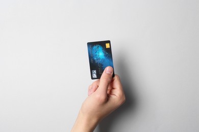 Photo of Man holding credit card on light grey background, closeup